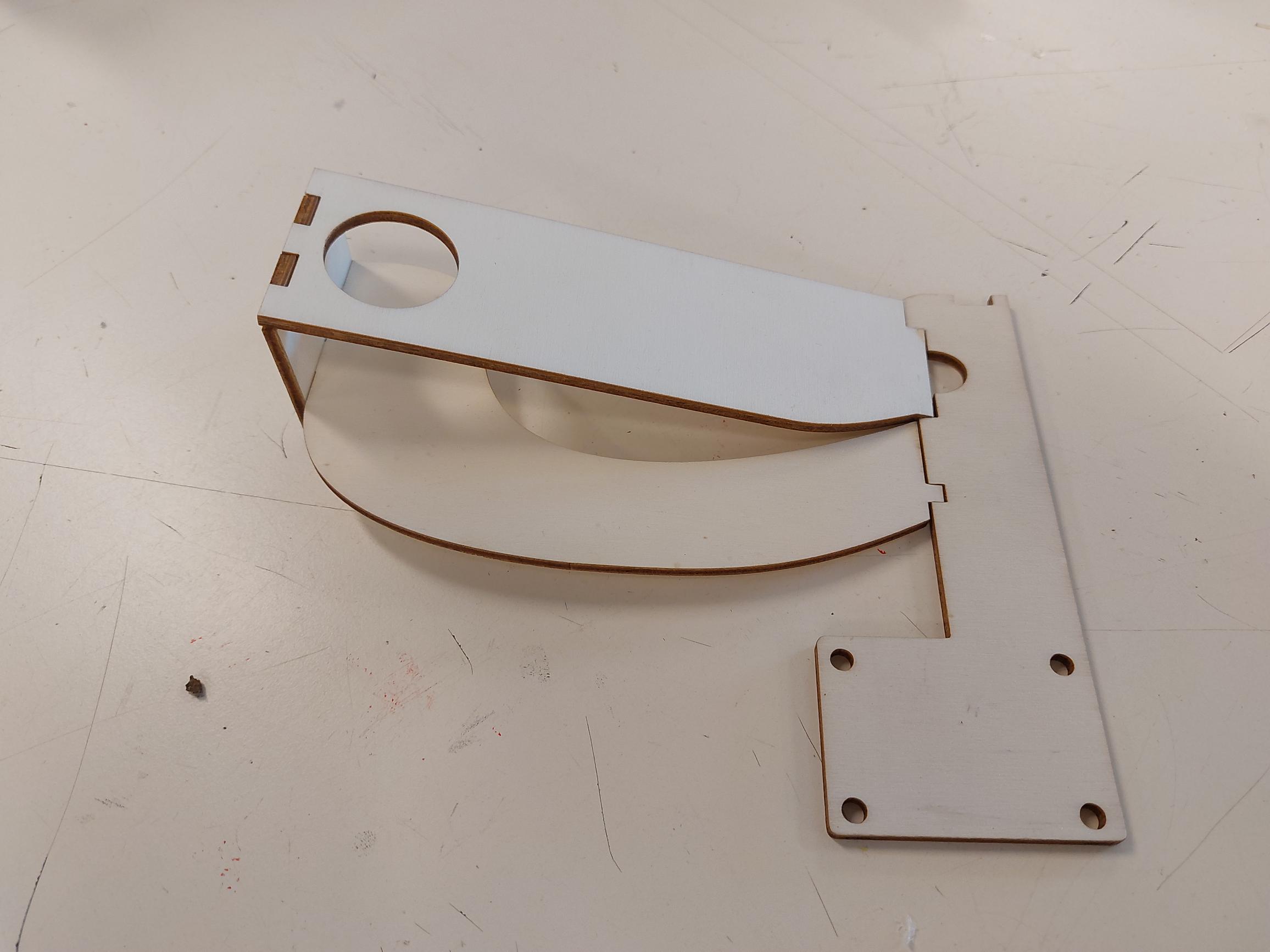 Het houten frame staat rechtop op de gebogen zijkant; de bodemplaat ligt ernaast.